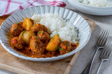 Sosisli köfte ve köri soslu patates ve pilav.