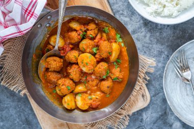 Sosisli köfte ve köri soslu patates ve pilav.