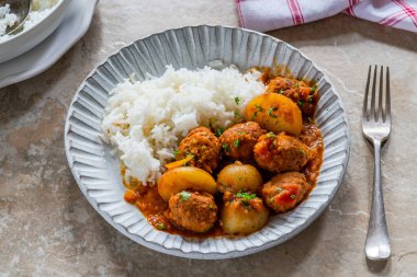 Sosisli köfte ve köri soslu patates ve pilav.