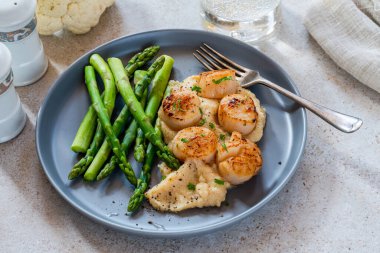 Karnabahar, fasulye püresi ve kuşkonmazlı kızarmış midye.