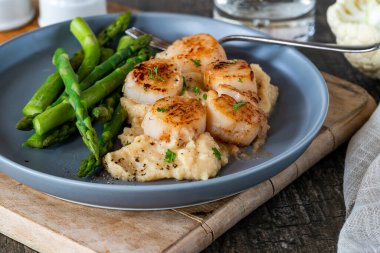 Karnabahar, fasulye püresi ve kuşkonmazlı kızarmış midye.