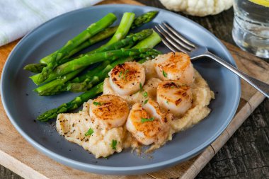 Karnabahar, fasulye püresi ve kuşkonmazlı kızarmış midye.