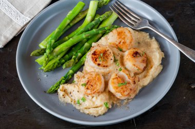 Karnabahar, fasulye püresi ve kuşkonmazlı kızarmış midye.