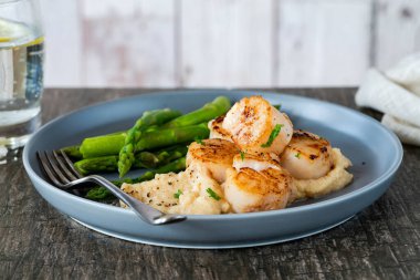 Karnabahar, fasulye püresi ve kuşkonmazlı kızarmış midye.