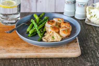 Karnabahar, fasulye püresi ve kuşkonmazlı kızarmış midye.