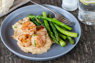 Karnabahar, fasulye püresi ve kuşkonmazlı kızarmış midye.