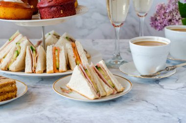 Seçenek gurme kekler ve küçük kanepeler kahve ve masada köpüklü şarap.