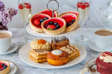 Selection of gourmet cakes with coffee and sparkling wine on a table