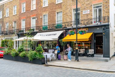 LONDON, İngiltere - Haziran 03, 2022: Belgravia bölgesinde sokak manzarası, akıllı butikler, lüks restoranlar, lüks restoranlar ve sofistike kafeler ile bilinen zengin bir bölge