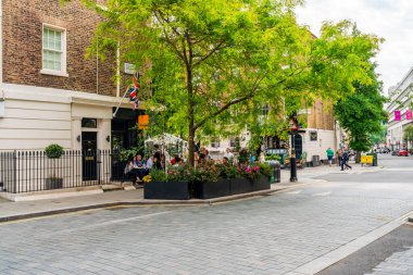 LONDON, İngiltere - Haziran 03, 2022: Belgravia bölgesinde sokak manzarası, akıllı butikler, lüks restoranlar, lüks restoranlar ve sofistike kafeler ile bilinen zengin bir bölge