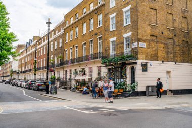 LONDON, İngiltere - Haziran 03, 2022: Belgravia bölgesinde sokak manzarası, akıllı butikler, lüks restoranlar, lüks restoranlar ve sofistike kafeler ile bilinen zengin bir bölge