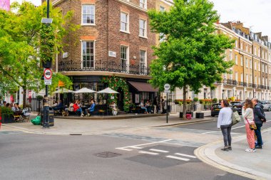 LONDON, İngiltere - Haziran 03, 2022: Belgravia bölgesinde sokak manzarası, akıllı butikler, lüks restoranlar, lüks restoranlar ve sofistike kafeler ile bilinen zengin bir bölge