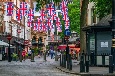 LONDON, İngiltere - Haziran 03, 2022: Londra 'nın merkezindeki bir caddenin üzerinde Kraliçe' nin Platin Kutlamaları münasebetiyle Birlik bayrakları asılı.