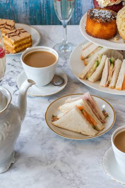 Seçenek gurme kekler ve küçük kanepeler kahve ve masada köpüklü şarap.