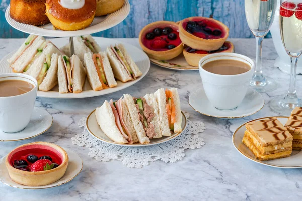 Selection of gourmet cakes and mini canapes with coffee and sparkling wine on a table