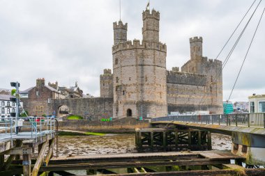 CAERNARFON, WALES - HAZİRAN 08, 2022: Caernarfon Kalesi harabeleri, Caernarfon, Gwynedd, kuzeybatı Galler 'de bir ortaçağ kalesi