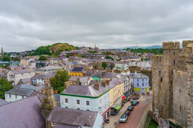 CAERNARFON, WALES - 08 Temmuz 2022: Ortaçağ Kalesi duvarlarından Caernarfon manzarası. Caernarfon Galler 'in Gwynedd şehrinde bulunan bir kraliyet şehridir.