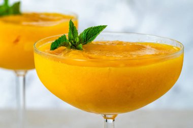 Frozen mango daiquiri with white rum garnished with fresh mint