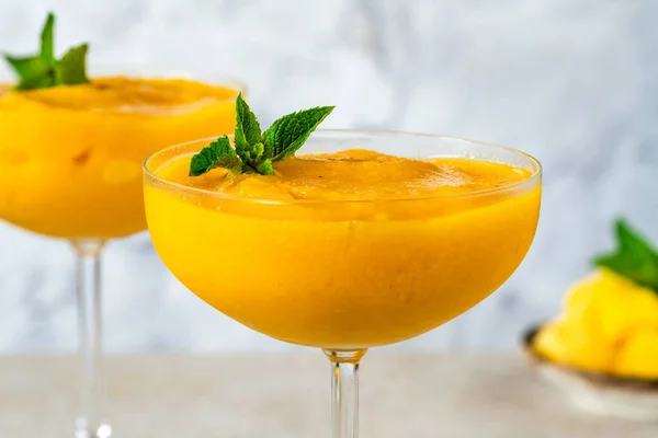 Frozen mango daiquiri with white rum garnished with fresh mint