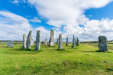 CALLANISH, ISLE OF LEWIS, SCOTLAND - AUGUST 03, 2022: Tourists visit Callanish standing stones site on the Isle of Lewis. The stones were erected in the late Neolithic era.