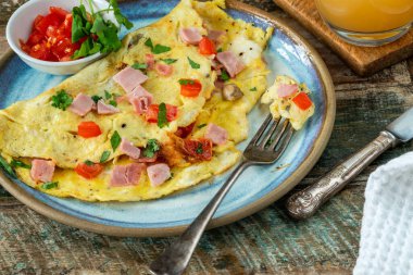 Egg omelette with ham, mushrooms and tomatoes