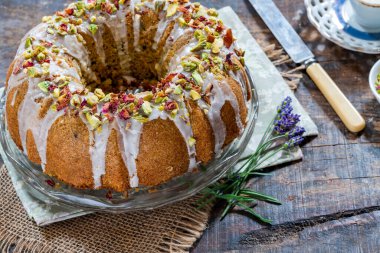 Vanilya kremalı, ezilmiş şam fıstığı ve kurutulmuş gül yapraklarıyla süslenmiş İran aşk pastası.