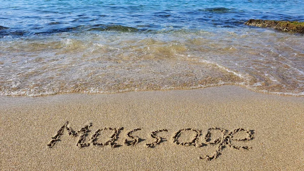 Слово Массаж написано на песке у моря . — стоковое фото