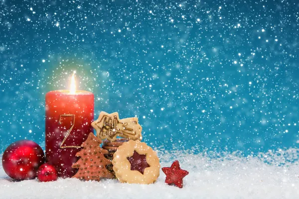 Druhá adventní svíčka se zlatou dekorací a vánočními sušenkami. — Stock fotografie