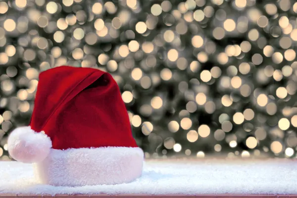 Красная шляпа Санты и белый снег. Рождественский фон . — стоковое фото