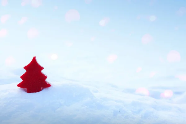Χριστουγεννιάτικο φόντο με κόκκινο έλατο σε λευκό χιόνι. — Φωτογραφία Αρχείου