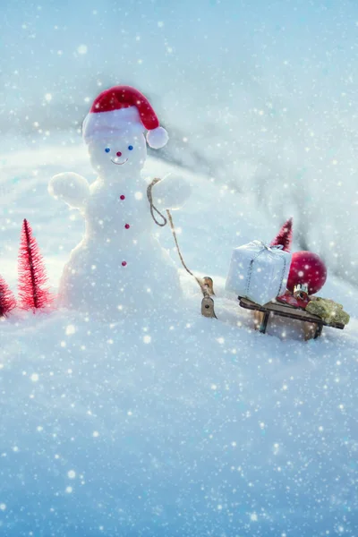 Рождественский фон со снеговиком и подарки стоят в белом снегу. — стоковое фото