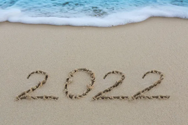 Capodanno 2022 scritto sulla spiaggia di sabbia caraibica con onde marine . — Foto Stock