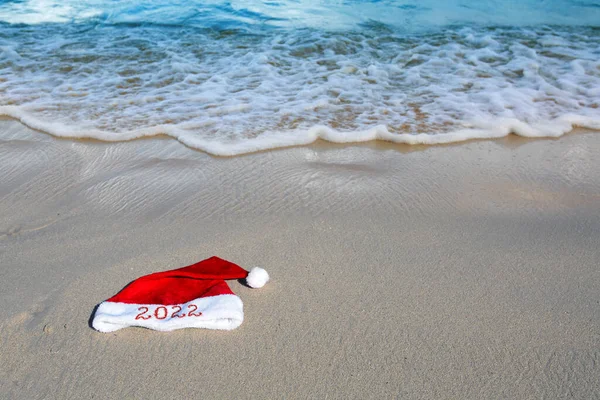 Capodanno 2022 scritto al cappello di Babbo Natale sulla spiaggia di caraibi. — Foto Stock