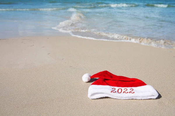 Nouvel An 2022 écrit au chapeau du Père Noël sur la plage des Caraïbes. — Photo