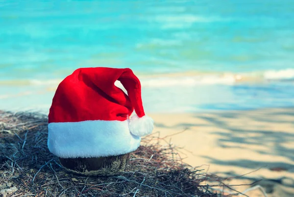 圣诞背景，红红的圣诞帽在加勒比海边. — 图库照片