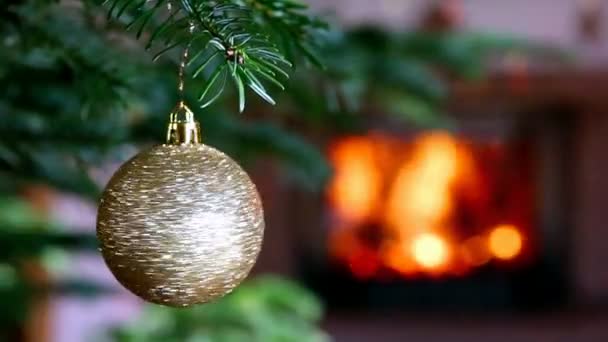 Καύσιμο τζάκι δίπλα στο διακοσμημένο χριστουγεννιάτικο δέντρο με χρυσά στολίδια. — Αρχείο Βίντεο