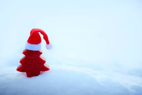 Karácsonyi háttér piros Mikulás kalap és fenyő fa fehér hó. — Stock Fotó