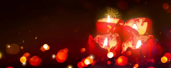 Quatre bougies de l'Avent avec des lumières de Noël dans la lumière atmosphérique. — Photo