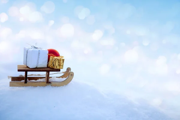 Boże Narodzenie tło z śniegu i drewna sanki stoją w białym śniegu. — Zdjęcie stockowe