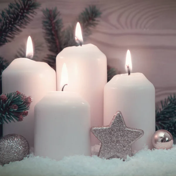 Feliz Navidad fondo con cuatro velas blancas de Adviento en la nieve. — Foto de Stock