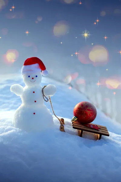 Χριστούγεννα φόντο με χιονάνθρωπο και δώρα σταθεί σε λευκό χιόνι. — Φωτογραφία Αρχείου