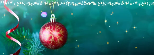 Χριστουγεννιάτικη κόκκινη μπάλα κρέμεται σε κλαδιά πεύκου με εορταστική φόντο — Φωτογραφία Αρχείου