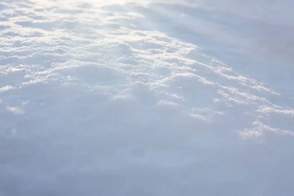 Verse sneeuw textuur achtergrond in blauwe toon en zonlicht. — Stockfoto