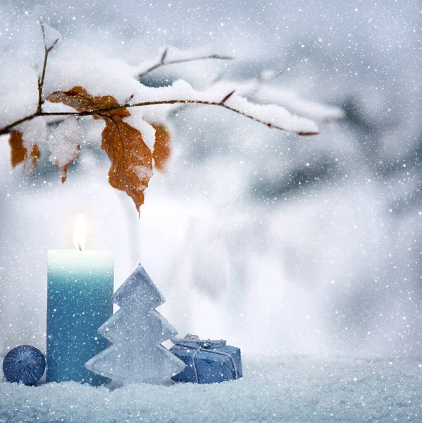 Vánoční modrá dekorace a adventní svíčka na sněhu. — Stock fotografie