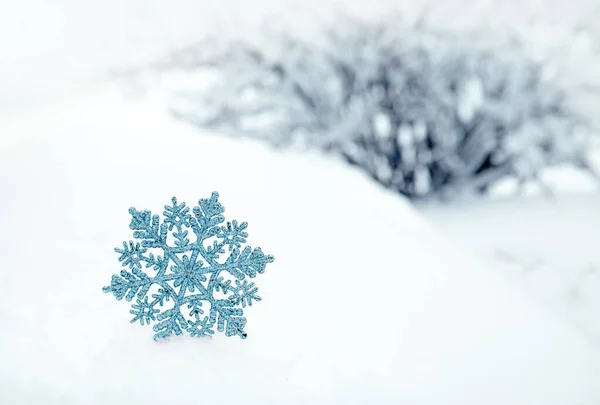 Boże Narodzenie tło z niebieskim płatkiem śniegu na białym śniegu. — Zdjęcie stockowe
