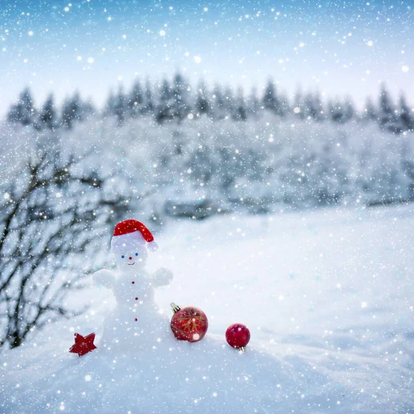 Boże Narodzenie tło z bałwanem i prezenty stoją w białym śniegu. — Zdjęcie stockowe