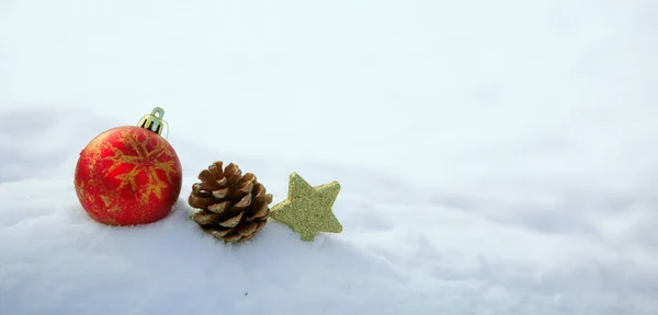 Weihnachten Hintergrund mit roter Kugel und Dekorationen auf weißem Schnee. — Stockfoto