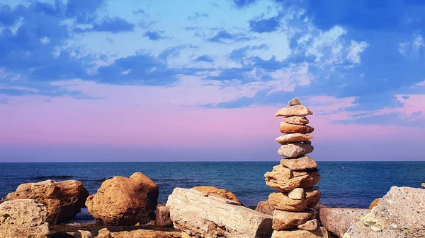 Piramide van stenen op het strand. Het concept van harmonie en ontspanning . — Stockfoto