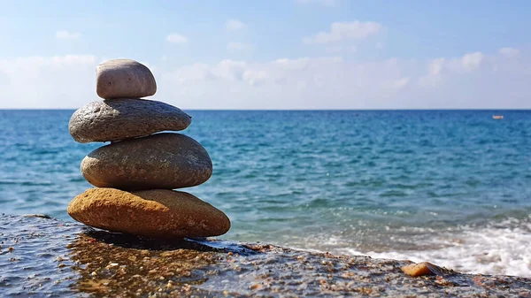 Pirámide de piedras en la playa. El concepto de armonía y relajación . — Foto de Stock