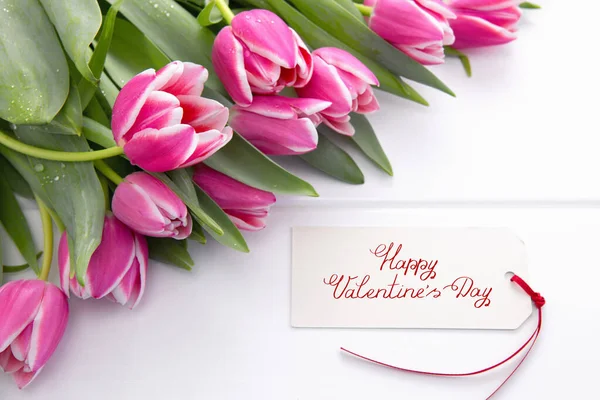 Valentines Day card and a bouquet of beautiful tulips on wooden background. — стокове фото